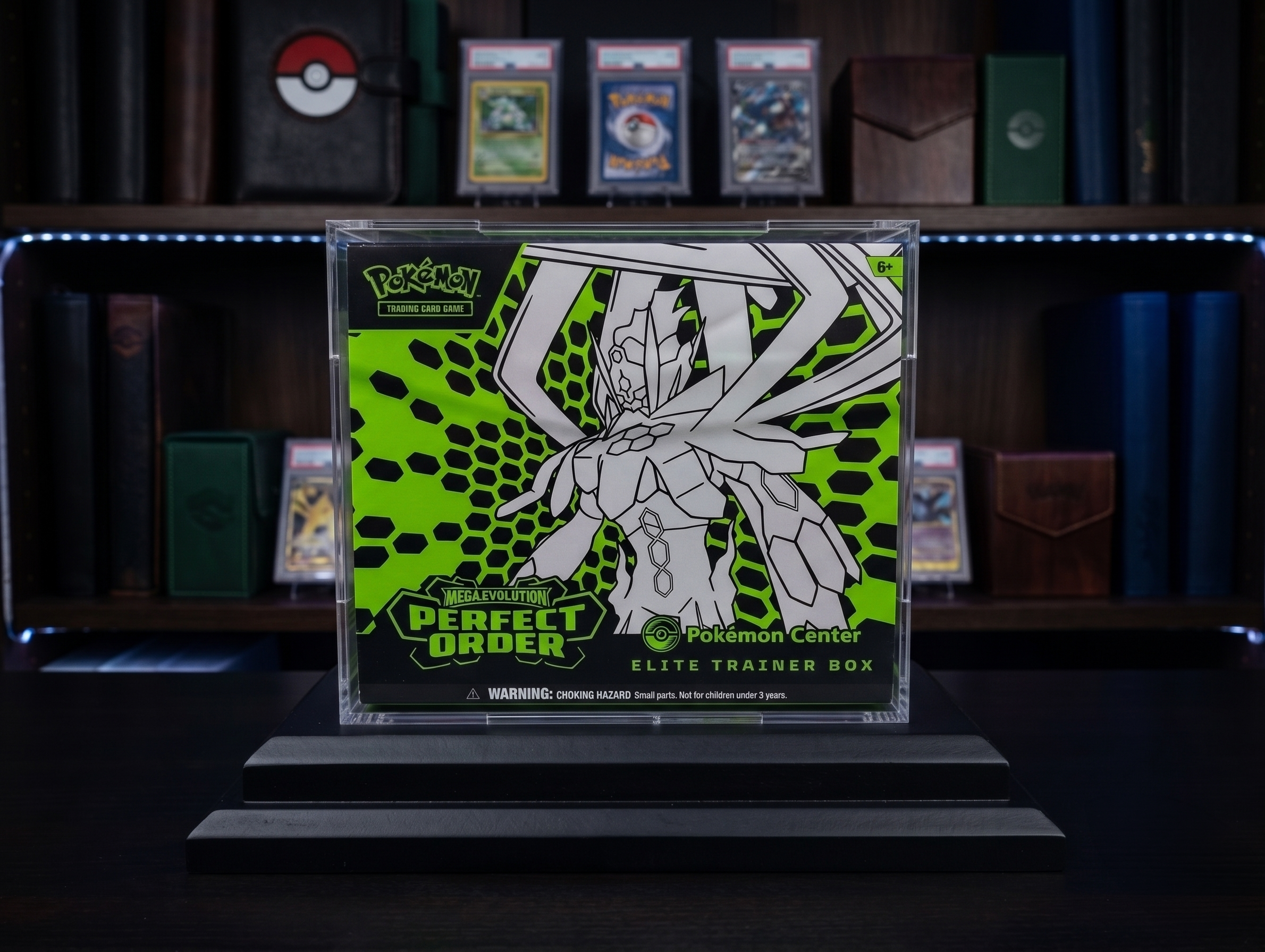 Pokémon trading card game box on a stand with Pokémon cards in the background